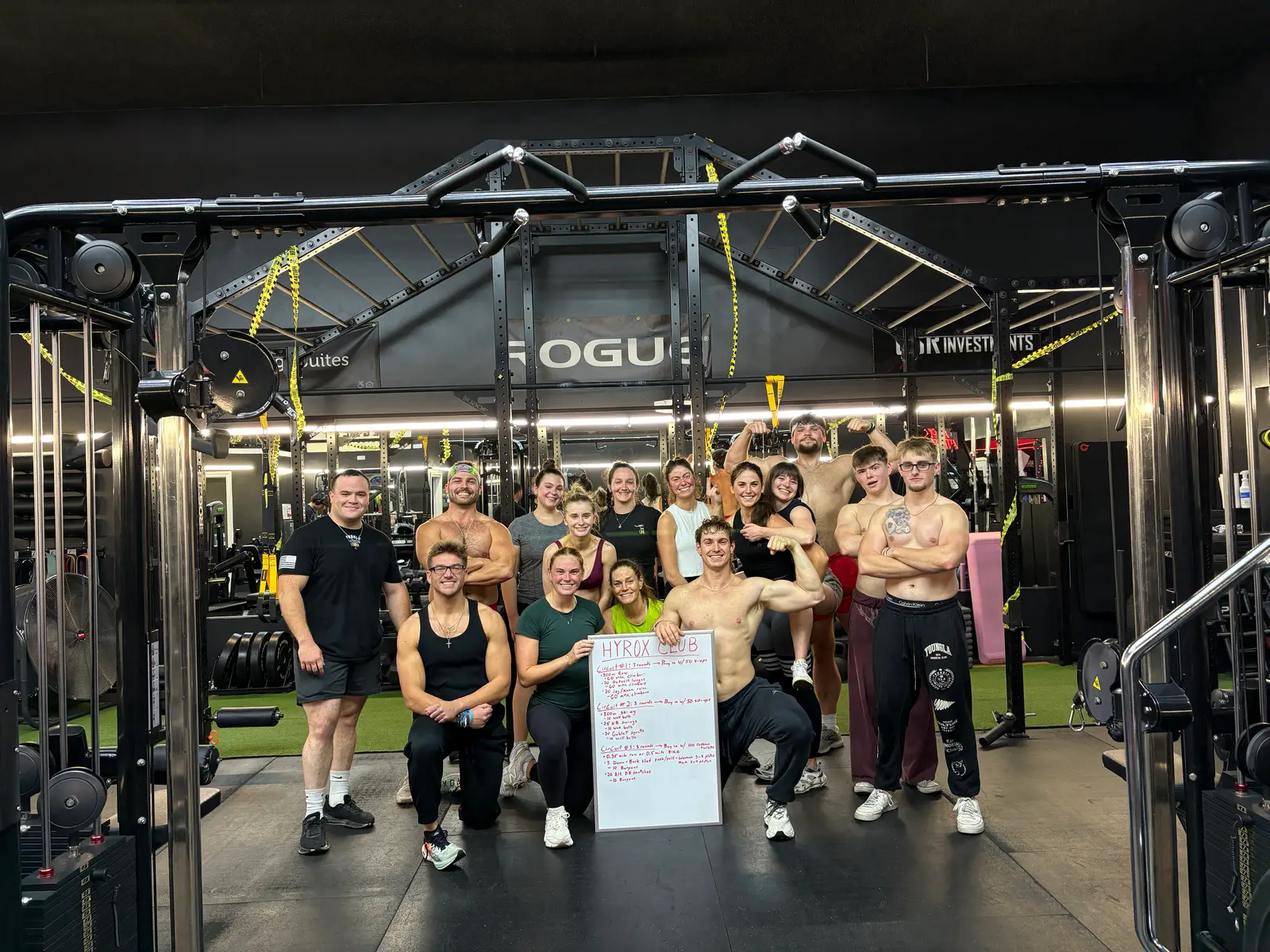 A group training class gathered on the turf under the Rogue rig at Aspire